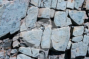 Natural gray stony background consisting of weathered pieces of splited mountain slate.