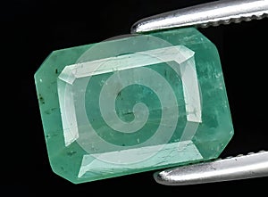 natural green emerald gem on the background