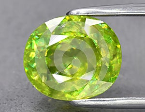 Natural green sphene gemstone isolated on white background