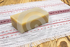 Natural handmade organic olive oil soap on the wooden table. Table doily with the soap.