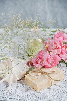 Natural handmade soap, aromatic oil and flowers on white wooden