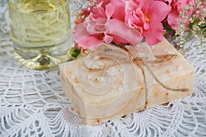 Natural handmade soap, aromatic oil and flowers on white wooden