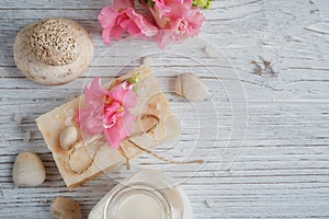 Natural handmade soap, aromatic oil and flowers on white wooden