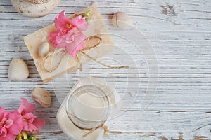 Natural handmade soap, aromatic oil and flowers on white wooden