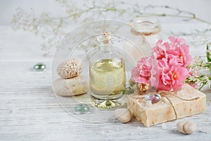 Natural handmade soap, aromatic oil and flowers on white wooden