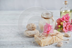 Natural handmade soap, aromatic oil and flowers on white wooden