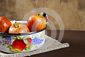 Natural and healthy tropical fruit apple in the bowl on the table on blurred texture background photo