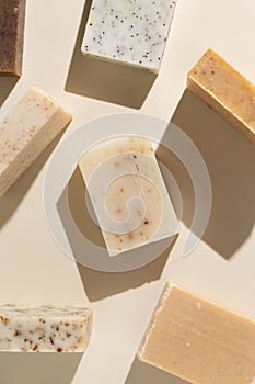 Natural herbal beige and brown soap bars on light beige top view, hard shadows photo