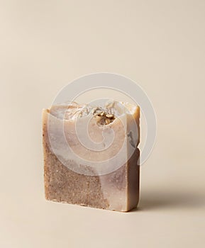 Natural herbal brown handmade soap bar on light beige close up photo