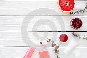 Natural herbal cosmetics with grapefruit on white wooden background top view space for text