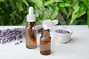 Natural herbal oil in glass bottles and lavender flowers