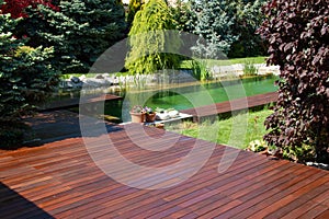 Natural home garden backyard with little pool lake, trees, plants and wooden decks, Ipe and cumaru decking