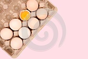 Natural homemade eggs in a tray. A tray of eggs on a white and pink background. eco tray with testicles. minimalistic trend, top