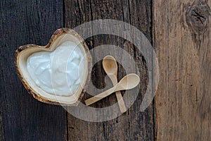 Natural homemade plain organic yogurt in wood bowl on wood texture background