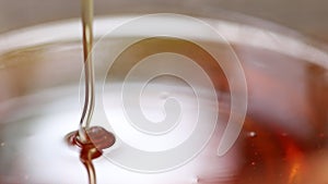 Natural honey dripping into a glass