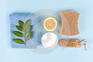 Natural household cleaners - baking soda, lemon, citric acid, bamboo brush, natural sponge on blue background with copy space photo