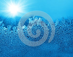 Natural ice pattern and sunlight on winter glass