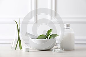 Natural ingredients for cosmetic products and laboratory glassware on white table