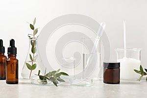 Natural ingredients for cosmetic products and laboratory glassware on white table