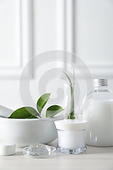 Natural ingredients for cosmetic products and laboratory glassware on white table