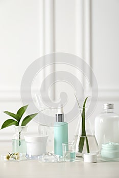 Natural ingredients for cosmetic products and laboratory glassware on white table