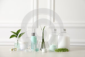 Natural ingredients for cosmetic products and laboratory glassware on white table