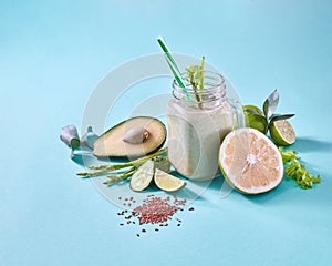 Natural ingredients for healthy smoothie from avocado with cucumber, celery, shpinach, lemon, flax seeds in glass jar on