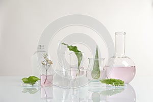 Natural ingredients and laboratory glassware for organic cosmetic product on white table