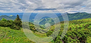 Prírodná krajina na úpätí vysokých tatier na severe Slovenska začiatkom leta so širokými dolinami a zelenými lúkami