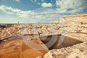 Natural landscape of Gozo Island with cavernous cliffs and stone-carved niches for salt mining. Malta scene