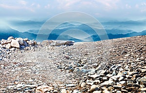 Natural landscape skyline with stone ground and rolling mountains.