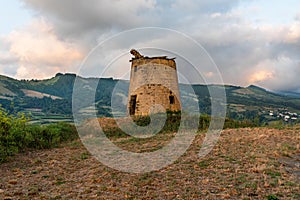 Natural landscape at sunset with old mill on the island of Sao Miguel, Azores, Portugal. Outdoors with no people and the sea in th