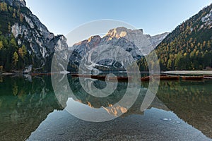 Natural landscapes of the lake Braies Lago di Braies with morning fog and reflection of the mountain peak in Dolomites, Italy photo