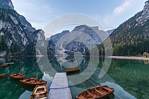 Natural landscapes of the lake Braies Lago di Braies with morning fog and reflection of the mountain peak in Dolomites, Italy photo