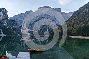 Natural landscapes of the lake Braies Lago di Braies with morning fog and reflection of the mountain peak in Dolomites, Italy photo