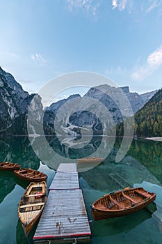 Natural landscapes of the lake Braies Lago di Braies with morning fog and reflection of the mountain peak in Dolomites, Italy photo