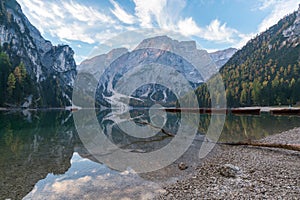 Natural landscapes of the lake Braies Lago di Braies with morning fog and reflection of the mountain peak in Dolomites, Italy photo