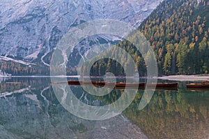 Natural landscapes of the lake Braies Lago di Braies with morning fog and reflection of the mountain peak in Dolomites, Italy photo