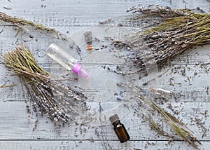 Natural lavender flowers bunches, essential lavender oil bottle, organic perfume spray over wooden background. Flatlay