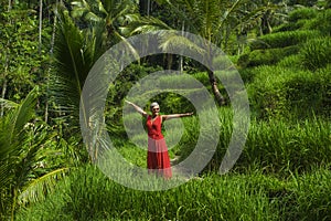 Natural lifestyle portrait of beautiful and happy middle aged 40s or 50s Asian woman with grey hair in stylish red dress walking