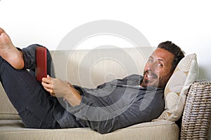 Natural lifestyle portrait of young handsome and successful self employed man working at home using laptop computer lying relaxed