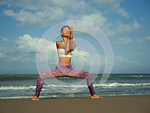 Natural lifestyle portrait of young happy and attractive fit and slim blond woman doing yoga and relaxation exercise outdoors at
