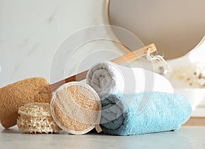 Natural loofah sponges and towels on table in bathroom