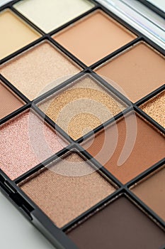 Natural look, Brown tone eye shadows make up palette in black case on white background. Selective focus. macro