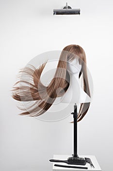 Natural looking brunet wig on white mannequin head