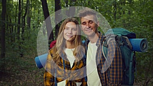 Natural marital therapy. Close up portrait of happy couple with backpacks and camping equipment smiling to camera