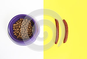 Natural meat sausages and dry dog food in a bowl