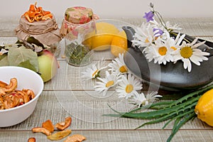 Natural medicine, fruits and herbs for seasonal colds, apple, lemon, aloe, herbal teas in jars, gray wooden