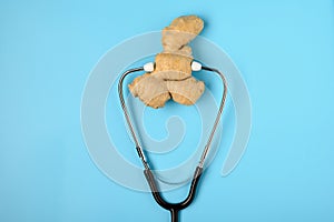 .Natural medicine. Immunostimulating products: ginger root. Ginger and stethoscope on a blue background, the concept of healthy