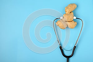 .Natural medicine. Immunostimulating products: ginger root. Ginger and stethoscope on a blue background, the concept of healthy